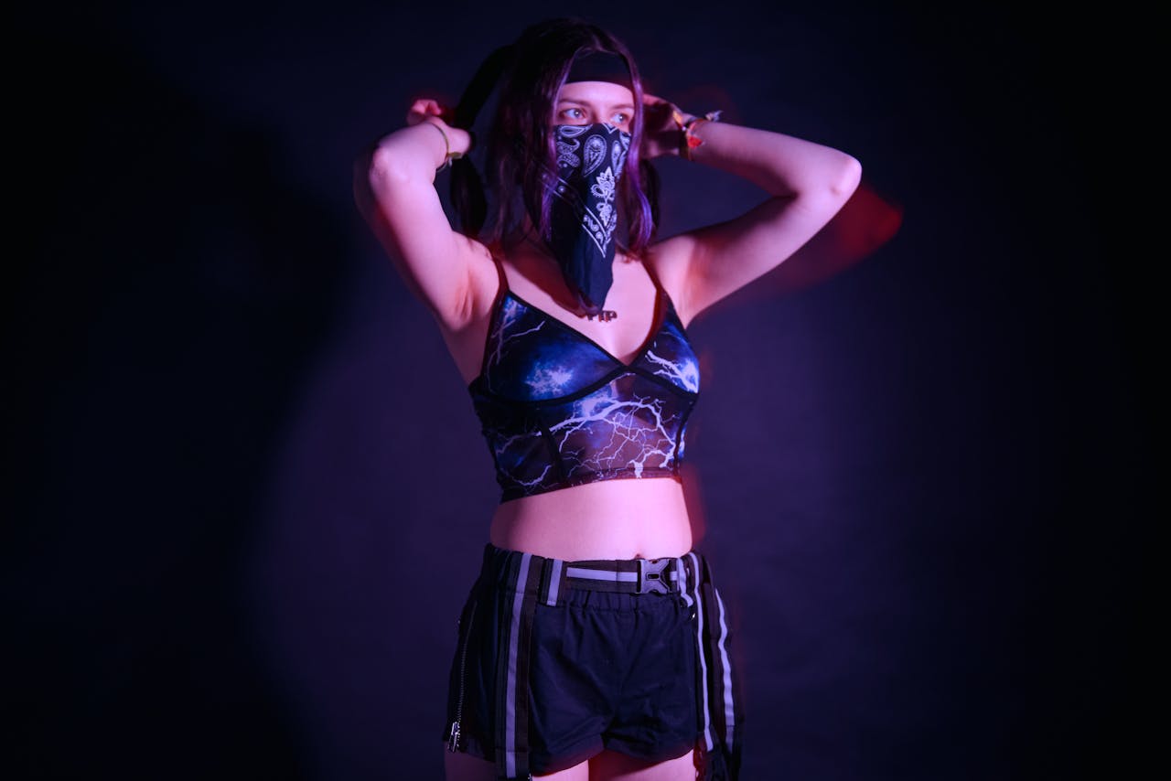 Woman with bandana and festival attire poses in fashion studio lighting.