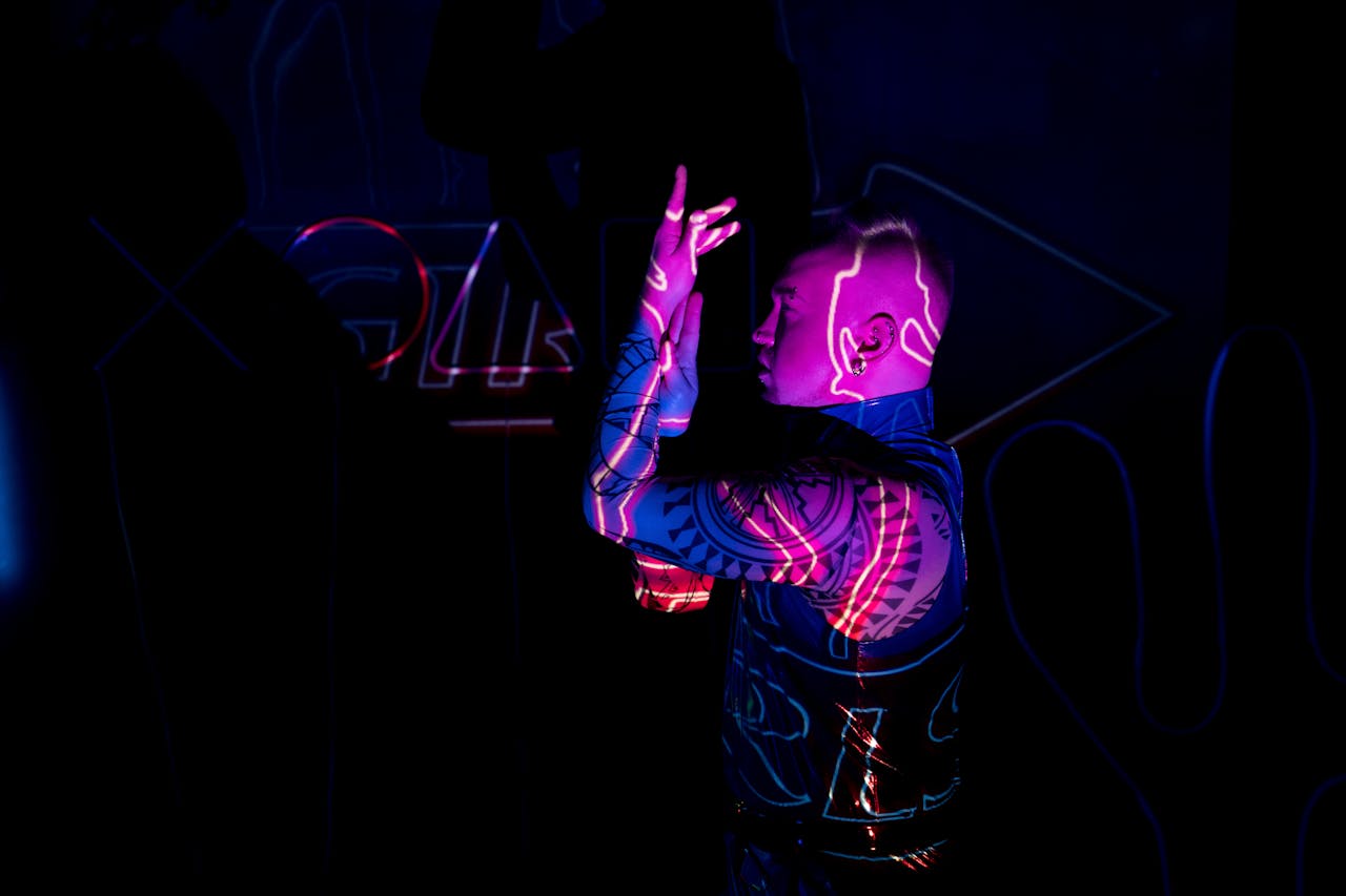 A man with neon-lit tattoos poses in a cyberpunk environment, surrounded by colorful lights.